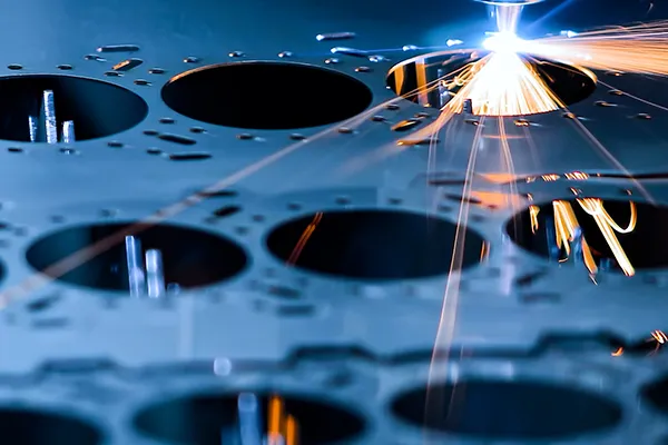 Ein Laser schneidet aus einem Metallblech Werkstücke für die Fertigung aus.
