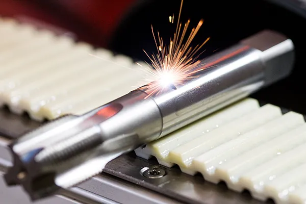 Auf einer Fertigungsstraße wird ein Werkstück mit einem Laser graviert und markiert.