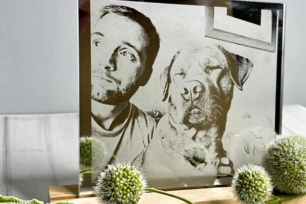 Ein gravierter Spiegel, auf dem ein Mann mit seinem Hund zu sehen ist.
